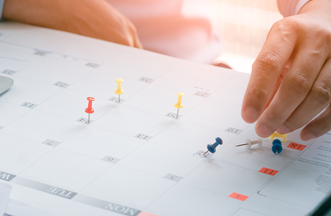 Planning digital advertising campaigns using a calendar with color‑coded pins and scheduling markers.
